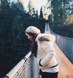 Person die von einer Brücke hinunter schaut